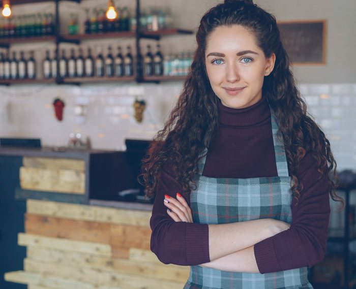A small business owner standing confidently in her café